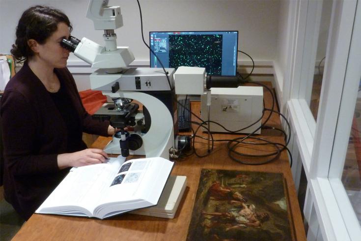 A conservationist looks through a microscope